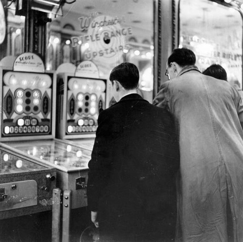 Two people looking - at, pinball